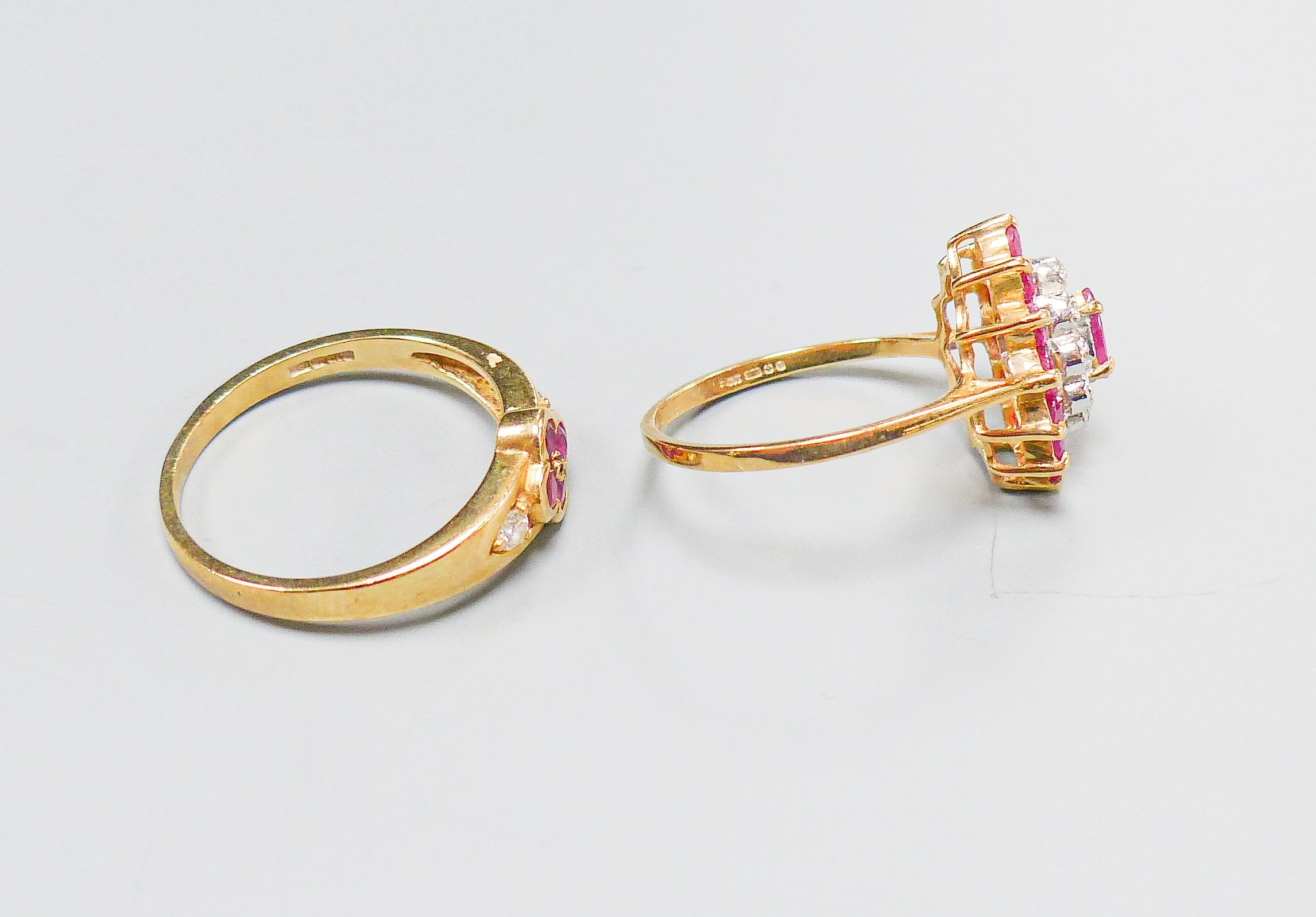 A 9ct yellow gold, ruby and diamond oval cluster ring, size M and another similar 9ct ring, gross 4.5 grams.